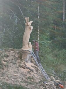 Travail en hauteur sur l'échelle pour sculpter le haut de l'œuvre en bois.