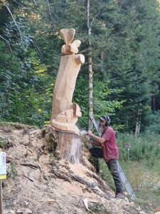 Sébastien Steffen façonnant les détails de sa sculpture monumentale à la tronçonneuse.