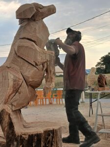 Étape intermédiaire d'une sculpture sur bois à la tronçonneuse représentant un animal dressé, façonnée par Sébastien Steffen.