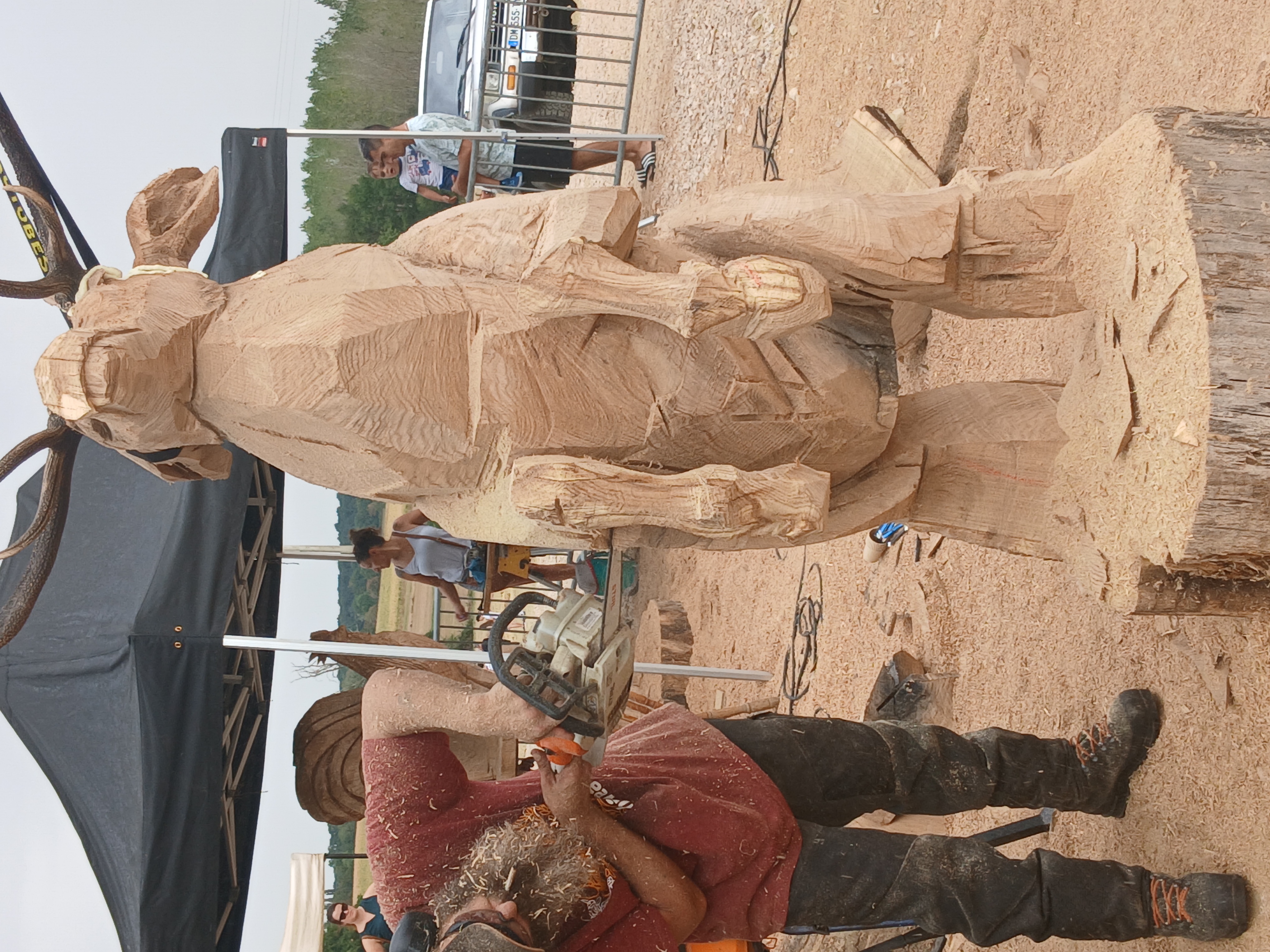 Sébastien Steffen apportant les dernières touches et finitions texturées sur la sculpture du cerf avec une petite tronçonneuse.