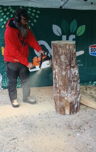 Sébastien Steffen en plein travail de sculpture à la tronçonneuse sous un chapiteau à Lullin.
