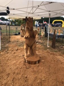 Vue d'ensemble de la sculpture de cheval en bois exposée sur le site de l'événement.