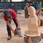 Étape de dégrossissage d'une sculpture sur bois à la tronçonneuse, forme d'animal visible